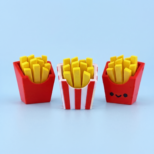 Three 3D printed french fries fidget clickers in plain red and striped cartons
