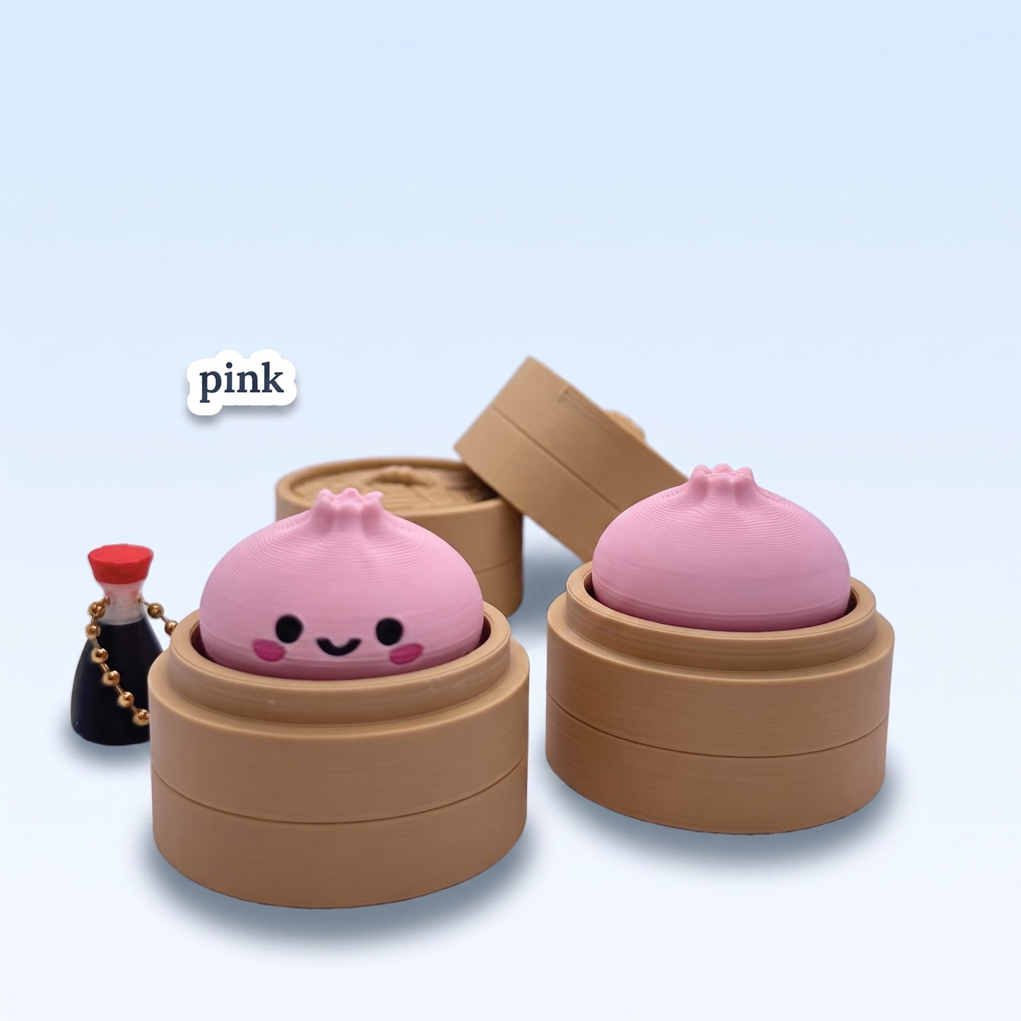 Pink Dumpling Fidget Clicker keychain in its steamer basket