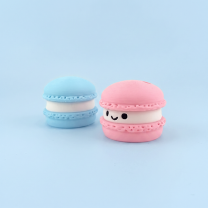 Blue and pink macaron fidget clickers, one with a smiley face