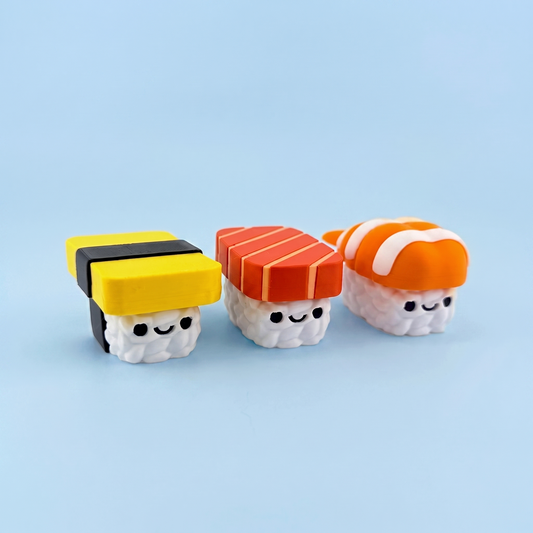 Three 3D printed nigiri sushi fidget clickers - tamago, salmon and prawn