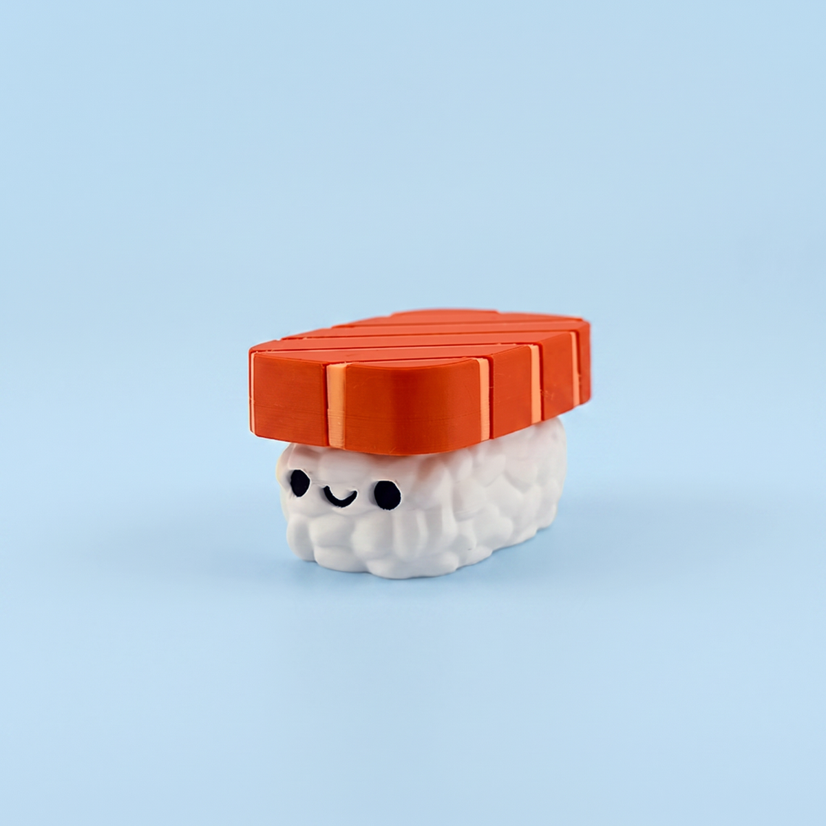 Salmon nigiri fidget clicker with a smiley face on the rice