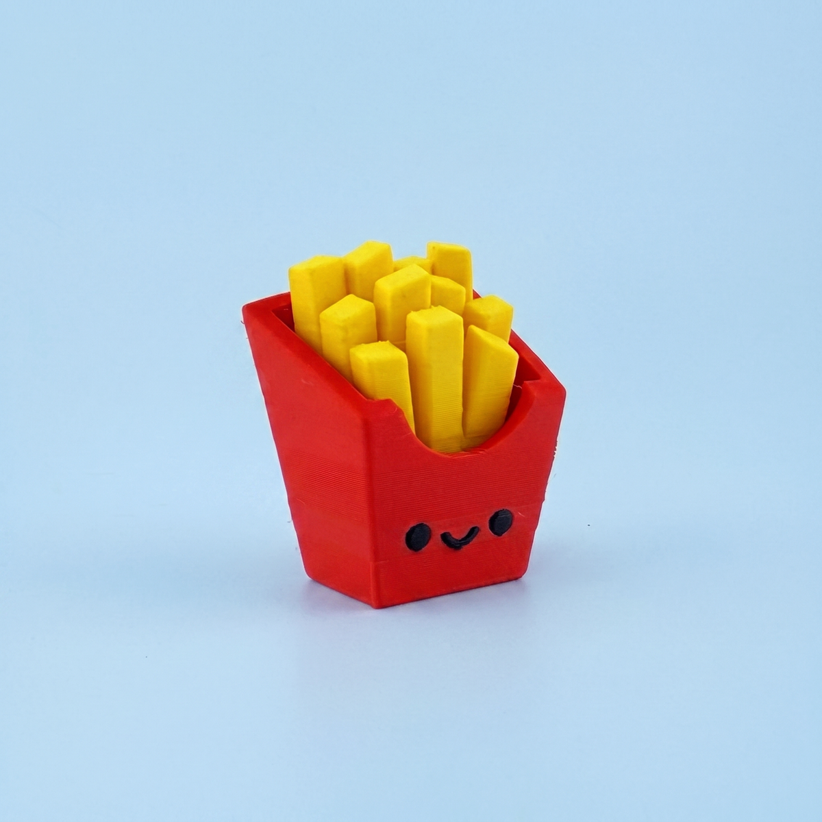 French fries fidget clicker in a plain red carton with a smiley face