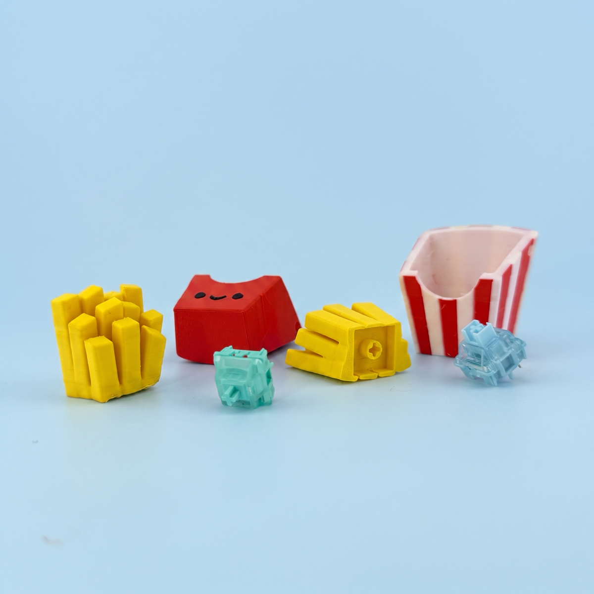French fries clicker parts laid out - printed carton, fries and the mechanical switches inside