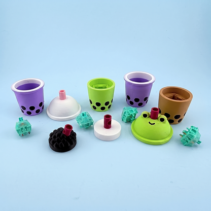 Bubble tea clicker parts laid out - printed cups, lids and the mechanical switches inside