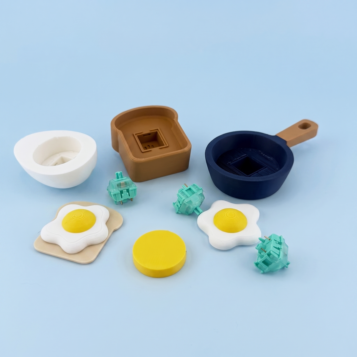 Eggscellent clicker parts laid out - printed pan, toast, egg shells and the mechanical switches inside