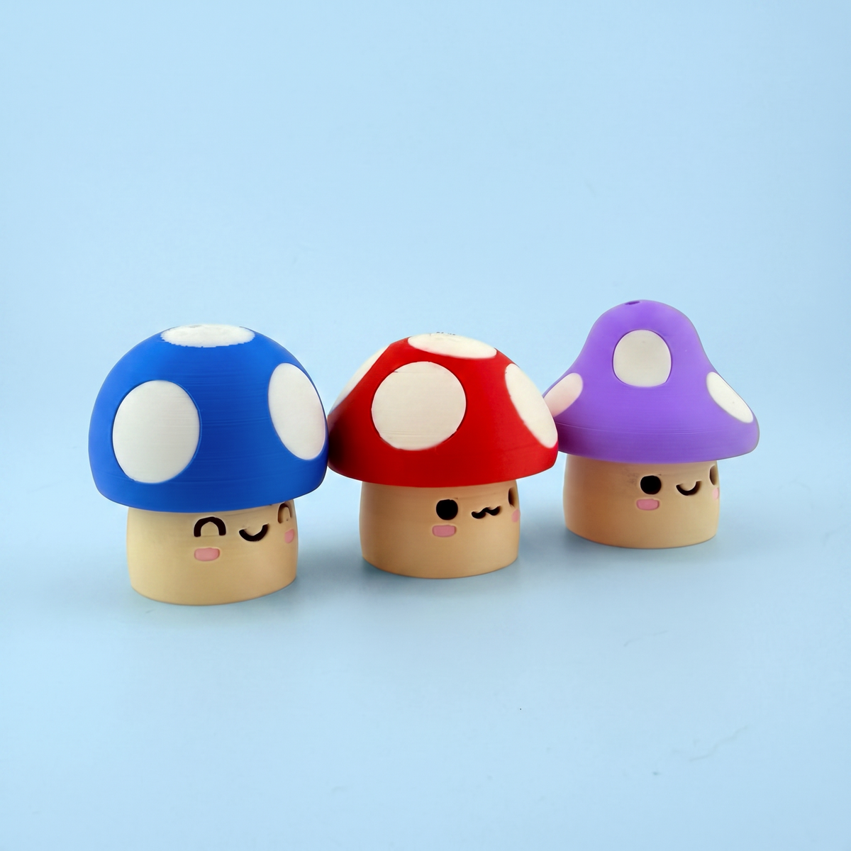 Mushroom fidget clickers lined up showing their sleepy printed faces