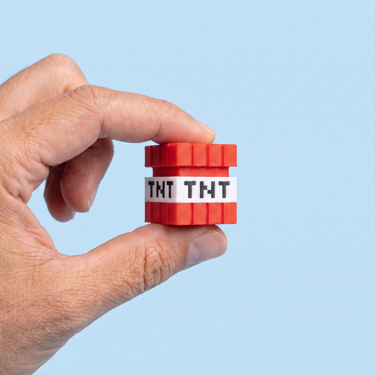TNT fidget clicker held between finger and thumb